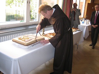Pater Josef Schulte schneidet den Jubiläumskuchen an