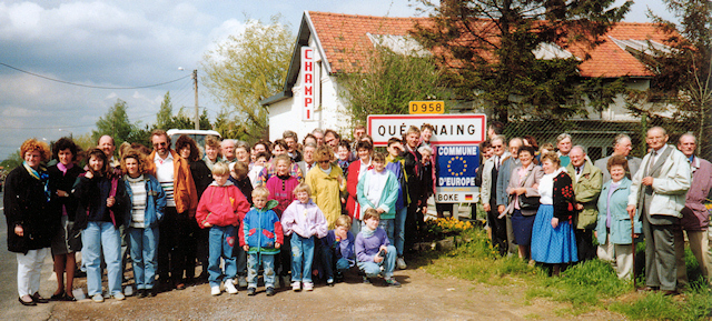Die Partnerschaftsfreunde vor dem mit dem Europa-Sternenkranz erweiterten Ortsschild von Quérénaing